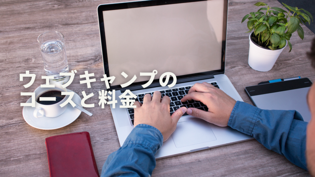 コーヒーと水を手元に置きながらパソコン作業する男性の手元
