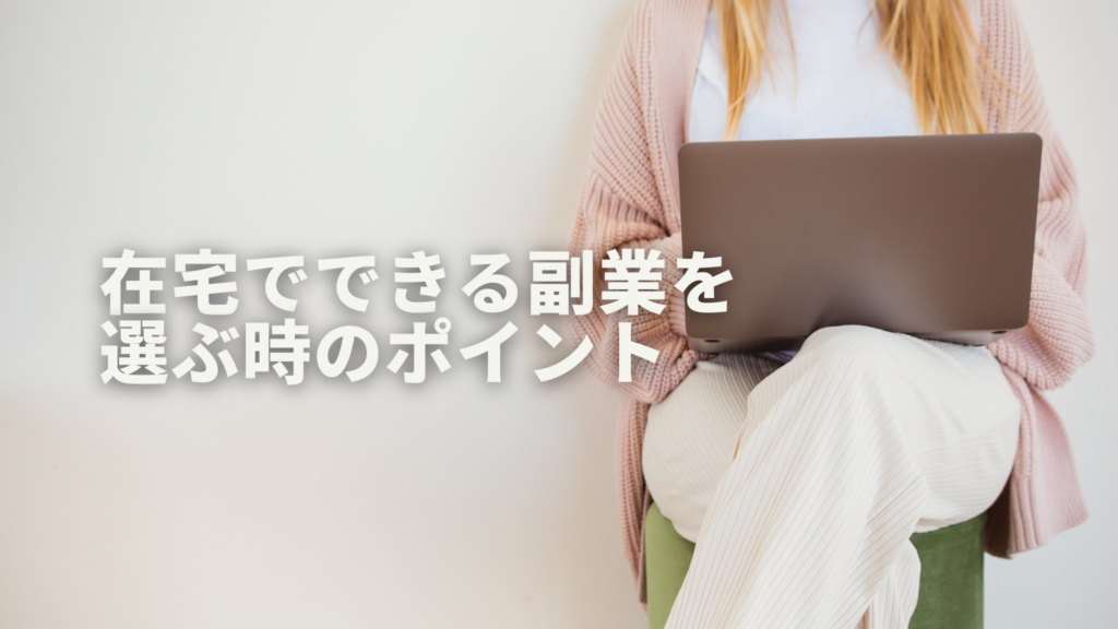 白い壁の前で緑のチェアに腰掛けて組んだ膝の上でパソコン作業をする女性の首から下