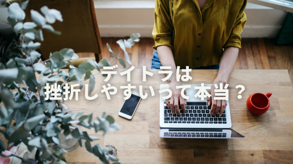 黄色のブラウスを着た女性が木のテーブルでパソコン作業をしています